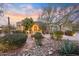 Beautiful Southwestern home features desert landscaping, stone accents, and a grand entrance illuminated by landscape lighting at 10040 E Happy Valley Rd # 269, Scottsdale, AZ 85255