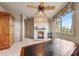 Bright office with a cozy fireplace, ceiling fan, and large windows, offering a comfortable workspace at 10040 E Happy Valley Rd # 269, Scottsdale, AZ 85255