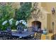 Charming outdoor patio featuring a fireplace, string lights, and lush greenery at 10040 E Happy Valley Rd # 269, Scottsdale, AZ 85255