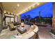 Elegant covered patio features a fireplace, comfortable seating, and a view of the pool at 10040 E Happy Valley Rd # 269, Scottsdale, AZ 85255