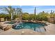 Backyard pool features rock accents, a waterfall, and mature landscaping with mountain views in the background at 10040 E Happy Valley Rd # 269, Scottsdale, AZ 85255