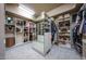 Spacious walk-in closet with custom shelving, mirrored drawers, and organized storage at 10040 E Happy Valley Rd # 269, Scottsdale, AZ 85255