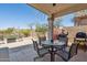 Cozy outdoor area with a covered patio, a built-in grill, a table, and desert landscaping at 10134 E Meandering Trail Ln, Gold Canyon, AZ 85118