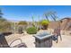 Desert-landscaped backyard with a stone patio and a fire pit sitting area at 10134 E Meandering Trail Ln, Gold Canyon, AZ 85118