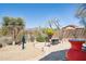 Desert-landscaped backyard with a stone patio, mountain views and a fire pit sitting area at 10134 E Meandering Trail Ln, Gold Canyon, AZ 85118