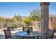 Covered patio with desert landscaping, a table set, and mountain views in the background at 10134 E Meandering Trail Ln, Gold Canyon, AZ 85118