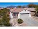 Charming single-story home featuring a red tile roof, neutral stucco, and a well-manicured desert landscape at 10134 E Meandering Trail Ln, Gold Canyon, AZ 85118