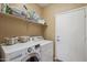Laundry room featuring a white washer and dryer set with overhead storage shelving at 10134 E Meandering Trail Ln, Gold Canyon, AZ 85118