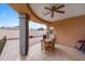 A covered patio area with tile flooring, ceiling fan, and a cozy outdoor dining set at 1031 W Cornell Dr, Tempe, AZ 85283