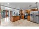Spacious kitchen featuring stainless steel appliances, wood cabinetry, and an island with a stone accent wall at 1031 W Cornell Dr, Tempe, AZ 85283