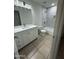 Bathroom featuring a modern vanity, marble tiled shower, and neutral ceramic floors at 10463 W Medlock Dr, Glendale, AZ 85307