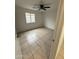 This neutral bedroom features tile flooring, a ceiling fan, and a window to let in natural light at 10463 W Medlock Dr, Glendale, AZ 85307
