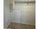 A walk-in closet is ready for your storage needs, featuring built in shelves and tile floor at 10463 W Medlock Dr, Glendale, AZ 85307
