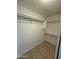 A functional walk-in closet is ready for your storage needs, featuring built in shelves and tile floor at 10463 W Medlock Dr, Glendale, AZ 85307
