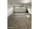This is an empty garage with an automatic door, and painted white walls at 10463 W Medlock Dr, Glendale, AZ 85307