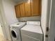 A laundry room featuring a washer, a dryer and wood cabinets at 10463 W Medlock Dr, Glendale, AZ 85307