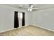 Spacious bedroom with ceiling fan, light wood floors, neutral walls, and a window with dark curtains at 11613 N 21St Ave, Phoenix, AZ 85029