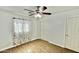 Cozy bedroom with a ceiling fan, laminate flooring, white walls, and floral curtains at 11613 N 21St Ave, Phoenix, AZ 85029