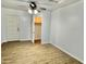 Bedroom with wood-look flooring, ceiling fan, closet with open door, and back door at 11613 N 21St Ave, Phoenix, AZ 85029