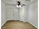 Bedroom with wood-look floors, ceiling fan, and white doors leading to other rooms at 11613 N 21St Ave, Phoenix, AZ 85029