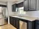Kitchen with stainless steel appliances, dark cabinetry, a window above sink, and light countertops at 11613 N 21St Ave, Phoenix, AZ 85029