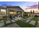 Cozy covered back patio with stylish furniture and a well-maintained backyard with pavers at 12531 W Tuckey Ln, Glendale, AZ 85307