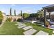 Inviting backyard with artificial turf, stepping stones, hot tub and lush landscaping at 12531 W Tuckey Ln, Glendale, AZ 85307