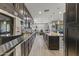 Modern kitchen with sleek dark cabinets, granite countertops, and stainless steel appliances at 12531 W Tuckey Ln, Glendale, AZ 85307