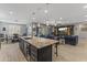 Open kitchen showcases granite counters on a large island and flows into the living room with a fireplace at 12531 W Tuckey Ln, Glendale, AZ 85307