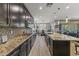 Contemporary kitchen featuring dark cabinets, granite countertops, and stylish pendant lighting at 12531 W Tuckey Ln, Glendale, AZ 85307