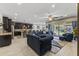 Open-concept living space with tile floors, comfortable sofas, and a well-equipped kitchen in the background at 12531 W Tuckey Ln, Glendale, AZ 85307