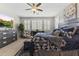 A sunlit main bedroom showcases a plush bed, plantation shutters, and a built-in media console at 12531 W Tuckey Ln, Glendale, AZ 85307