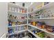 Walk-in pantry with ample shelving stocked with food, drinks, and household items at 12531 W Tuckey Ln, Glendale, AZ 85307