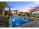 Backyard pool features nighttime lighting, lush landscaping, water features, and patio at 12531 W Tuckey Ln, Glendale, AZ 85307