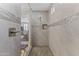 A glass enclosed shower features decorative tiling, a shower niche, and a view into the attached bedroom at 12531 W Tuckey Ln, Glendale, AZ 85307