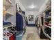 Bright walk-in closet with custom shelving, ample storage space, and a stylish blue ottoman at 12531 W Tuckey Ln, Glendale, AZ 85307