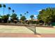 Exterior shot of a community tennis court in front of residences and palm trees at 1351 N Pleasant Dr # 2006, Chandler, AZ 85225