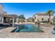 Backyard oasis offering a sparkling pool, comfortable lounge seating, and a serene desert landscape at 1523 N 103Rd St, Mesa, AZ 85207