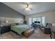 Comfortable main bedroom with wood accent wall, ceiling fan, and desk space by window at 1550 E Park Ave, Gilbert, AZ 85234