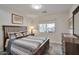 Bedroom with comfortable bed, wooden accents, a large window to let in natural light and modern flooring at 16131 W Indianola Ave, Goodyear, AZ 85395