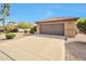 Attached two-car garage with paved driveway, desert landscaping, and a brown garage door at 16131 W Indianola Ave, Goodyear, AZ 85395