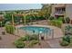 Community pool surrounded by an iron fence and beautiful desert landscaping with lounge chairs at 16616 E Palisades Blvd # 109, Fountain Hills, AZ 85268