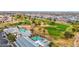 Aerial view featuring the pool, clubhouse, and golf course, with lush landscapes and mature trees at 17443 N Goldwater Dr, Surprise, AZ 85374
