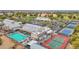 Aerial view showcasing the tennis courts, pool, and clubhouse with beautifully manicured landscapes at 17443 N Goldwater Dr, Surprise, AZ 85374