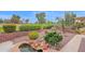 Landscaped backyard has a rock garden, waterfall feature, and lush green trees at 17443 N Goldwater Dr, Surprise, AZ 85374