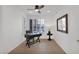 A home office with a large shuttered window, desk, and ceiling fan at 17443 N Goldwater Dr, Surprise, AZ 85374