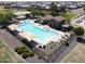 Aerial view of a beautiful community pool with lounge chairs, splash pad, covered seating area and tiled roof building at 19072 N Ventana Ln, Maricopa, AZ 85138