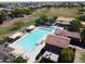 Aerial view showcasing a sparkling community pool with lounge chairs and tiled roofed buildings at 19072 N Ventana Ln, Maricopa, AZ 85138