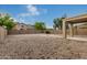 Spacious backyard with stone landscaping, brick fire pit area, and covered patio, great for outdoor entertaining at 19072 N Ventana Ln, Maricopa, AZ 85138