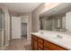 Double sink bathroom vanity with warm toned walls and walk-in closet access at 19072 N Ventana Ln, Maricopa, AZ 85138